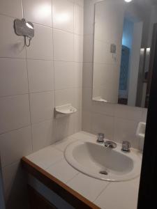 Baño blanco con lavabo y espejo en La Casa de la Isla en San Martín de los Andes