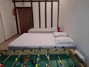 een kamer met een bed en een tafel met hockeybats bij location petit gite individuel in Orgères