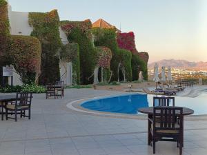 ein Resort mit einem Pool, Tischen und Stühlen in der Unterkunft Eden Rock Hotel Namaa Bay in Sharm El Sheikh