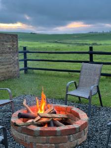 a fire pit with two chairs and a chair and a chair at Rosetta Fields Country Lodge in Henburg Park