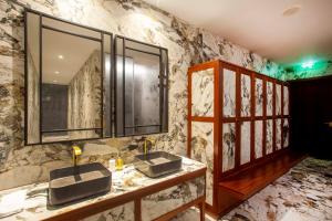a bathroom with two sinks and a marble wall at Wine & Books Porto Hotel in Porto