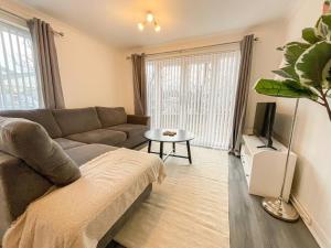 a living room with a couch and a tv at 49 Saxon Mill, Tamworth in Tamworth