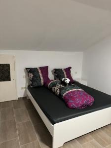 a bed with pillows on it in a room at Wohnung mit Küche, Fernseher, WLAN und Parkplatz - Brian in Werne an der Lippe