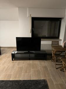 een woonkamer met een flatscreen-tv en een tafel bij Wohnung mit Küche, Fernseher, WLAN und Parkplatz - Brian in Werne an der Lippe