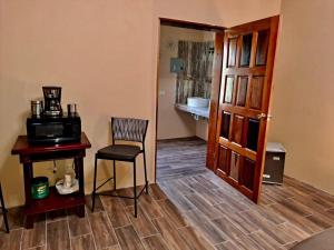Zimmer mit einem Tisch, einem Stuhl und einer Tür in der Unterkunft Banyan Rose Room 3 in Orange Walk Town