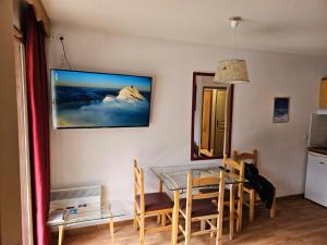 a kitchen and dining room with a glass table and chairs at Les 3 Vallées - Hameau des eaux d'Orelle - Appartement 003 in Orelle