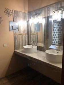 two sinks in a bathroom with two mirrors at Banyan Rose Room 3 in Orange Walk