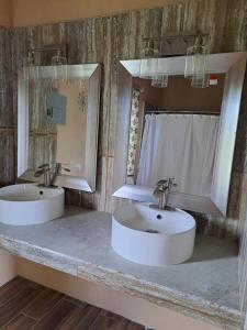 ein Badezimmer mit zwei Waschbecken und zwei Spiegeln in der Unterkunft Banyan Rose Room 3 in Orange Walk Town