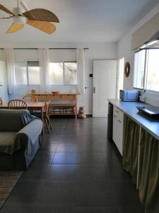 cocina y sala de estar con mesa y sofá en Casa Jardín. Vivienda rural en zona tranquila. en Lucainena de las Torres