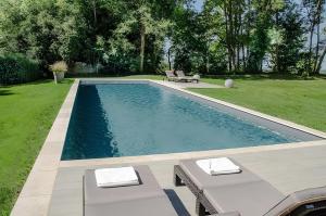 a swimming pool with two chairs and a table at Les Hauts de Sauliès - Chambre et Table d'Hôtes de charme in Vers