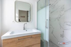 uma casa de banho com um lavatório e um espelho em Quiet cosy and large apartment with Terrace Top location em Saint-Ouen