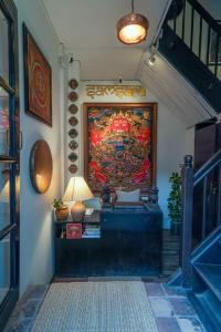 a hallway with a painting on the wall and a lamp at Samsara Apartments by Baber Mahal Revisited in Kathmandu