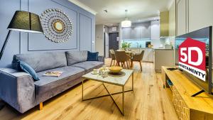 sala de estar con sofá azul y cocina en Rezydencja Niechorze 124 - 5D Apartamenty en Niechorze