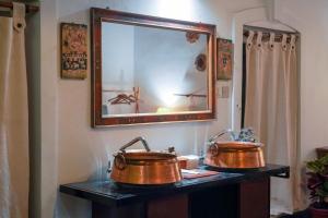 two copper pots on a table with a mirror at Samsara Apartments by Baber Mahal Revisited in Kathmandu