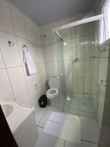 a bathroom with a glass shower and a toilet at Pousada Route 58 in Gravataí