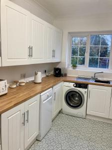 a kitchen with white cabinets and a washing machine at Fairfax in Southend-on-Sea