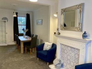 a living room with a table and a mirror over a fireplace at Fairfax in Southend-on-Sea