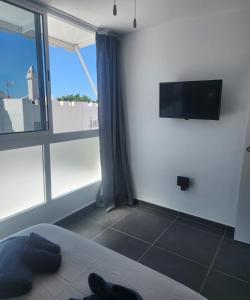 a bedroom with a bed and a large window at Bungalow del sol in Playa del Ingles