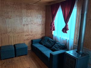 sala de estar con sofá azul y ventana en Casa Independiente Ciudad de Chonchi en Chonchi