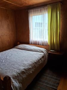 a small bedroom with a bed and a window at Casa Independiente Ciudad de Chonchi in Chonchi