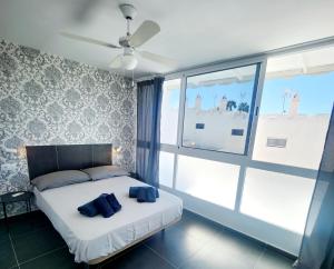a bedroom with a bed with two blue pillows on it at Bungalow del sol in Playa del Ingles +29 photos