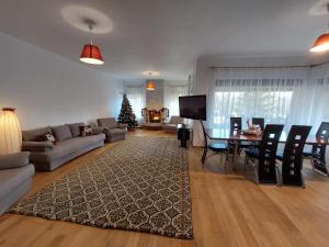 a living room with a couch and a table with a christmas tree at Paradisul Verde al Nathaliei in Cornu de Jos