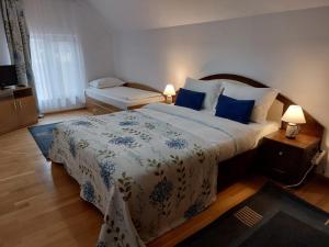a bedroom with a large bed with blue and white sheets at Paradisul Verde al Nathaliei in Cornu de Jos