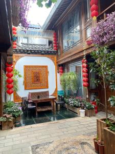 une cour avec une table et des chaises dans un bâtiment dans l'établissement Old Town of Lijiang Meiliju Inn, à Lijiang