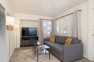 a living room with a couch and a tv at Mission Bay Cottage - Bay View Patio, Parking, WasherDryer in San Diego