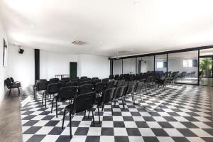 um quarto com cadeiras pretas num piso xadrez em Hotel Cartagena DC em Cartagena de Indias