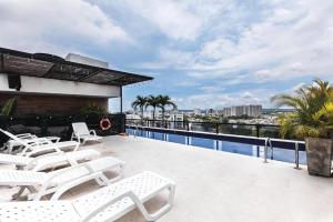 uma varanda com cadeiras brancas e uma piscina em Hotel Cartagena DC em Cartagena de Indias mais 37 fotografias