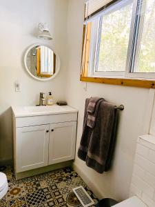 een badkamer met een wastafel en een spiegel bij Peaceful lakeside cottage great for a staycation. in Dwight