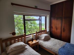 Ένα ή περισσότερα κρεβάτια σε δωμάτιο στο iGolomi Hillside Cottage