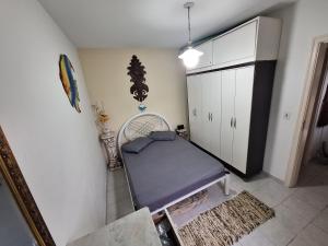 a room with a bed and a cabinet at PARAÍSO Ubatuba - Praia Grande-Toninhas - Apartamento Cond Wembley Tenis in Ubatuba