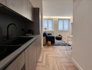 a kitchen with a sink and a living room at YLS Luxury Suites 2 in Milan