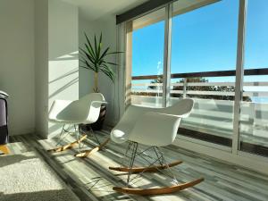 2 weiße Stühle in einem Zimmer mit einem großen Fenster in der Unterkunft Estupendo Preciosas Vistas in Alicante