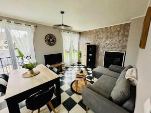 a living room with a couch and a table at Gîte "clé de la Baie" avec jacuzzi jusqu'à 7 pers in Woincourt