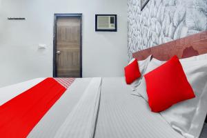 ein Schlafzimmer mit einem großen Bett mit roten Kissen in der Unterkunft OYO Flagship Hotel Skyorchid in Ābādpura
