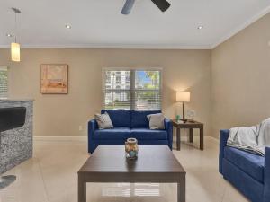 a living room with blue couches and a coffee table at Beach Isles Modern 1BR in Fort Lauderdale with Patio in Fort Lauderdale