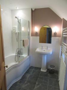 y baño con lavabo y ducha. en Holiday Cottage in Snowdonia (Sleeps 10), en Harlech