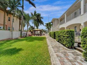a lawn in front of a building with palm trees at Beach Isles Modern 1BR in Fort Lauderdale with Patio in Fort Lauderdale