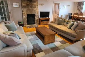 ein Wohnzimmer mit 2 Sofas und einem Kamin in der Unterkunft Holiday Cottage in Snowdonia (Sleeps 10) in Harlech