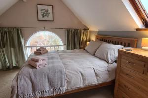 a bedroom with a large bed and a window at Holiday Cottage in Snowdonia (Sleeps 10) in Harlech