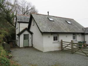 una casa blanca con una puerta verde y una valla en Holiday Cottage in Snowdonia (Sleeps 10), en Harlech