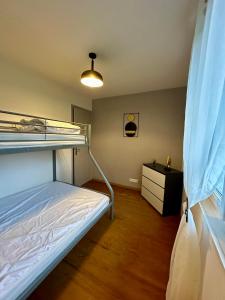 a bedroom with a bunk bed and a desk at Gîte "clé de la Baie" avec jacuzzi jusqu'à 7 pers in Woincourt