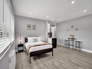 a white bedroom with a bed and a table at Coastal Charm Studio Retreat near Pompano Beach in Pompano Beach
