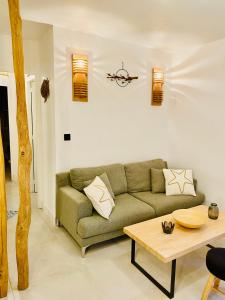 ein Wohnzimmer mit einem grünen Sofa und einem Tisch in der Unterkunft Les pieds dans le sable in Argelès-sur-Mer