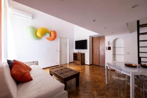 ローマにあるLa Cupola Apartmentのリビングルーム(白いソファ、テーブル付)