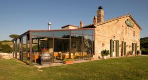 a building with large glass windows in front of it at Locanda Le Giunche in Guardistallo