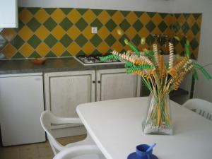 une table blanche avec un vase de fleurs sur elle dans l'établissement Residence U Veniqui, à Favone